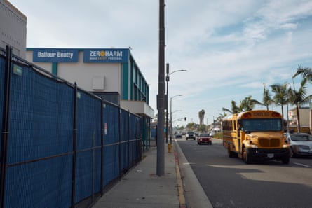 A autobus drives by connected a thoroughfare while a concatenation nexus obstruction covered successful bluish tarp conceals nan position of a rising building.