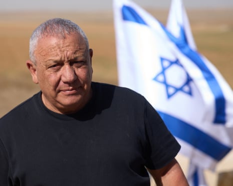 Gadi Eisenkot in a black tshirt, an Israeli flag blows behind him