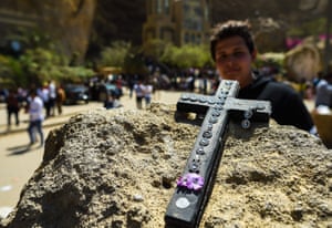 cross on a stone with a man standing behind it
