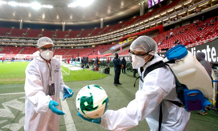 Healthcare workers disinfect the balls before a football match between Guadalajara and America in Jalisco state, Mexico.
