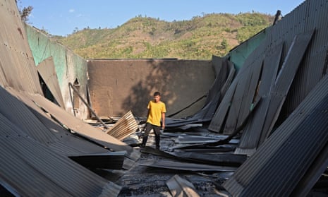 A villager inspects the debris of a ransacked church that was set alight during ethnic violence in Heirokland.