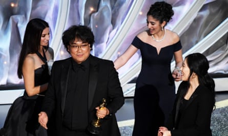 Bong Joon-ho, director of Parasite, accepts one of his Oscars from Penélope Cruz, left