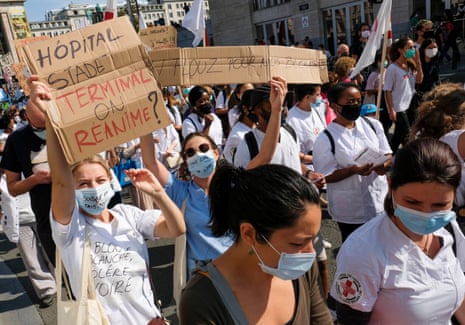 People wearing face masks carry placards during a health sector protest in Brussels, Belgium. Workers, patients, caregivers and associations united to demand the refinancing of healthcare and oppose the growing macro-commodification of the sector.