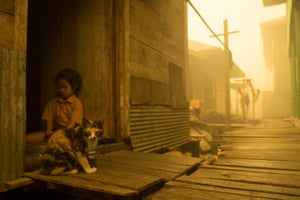 Child and cat seen at Sei Ahass village, where the air is engulfed with thick haze from the forest fires