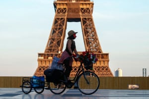 A woman rides her bicycle near the Eiffel tower at Trocadero square in Paris.