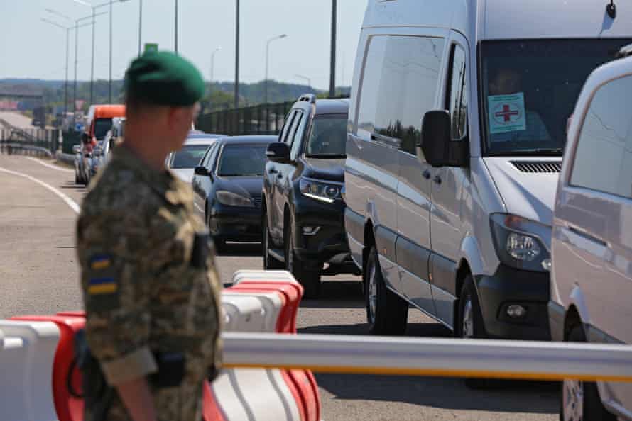 Un garde-frontière regarde les voitures faisant la queue au point de contrôle de Krakovets-Korczowa à la frontière entre l'Ukraine et la Pologne.