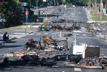 A street blocked by debris and burnt-out items after overnight unrest in the Magenta district of Noumea, New Caledonia, May 2024.