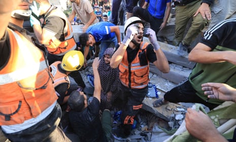 A Palestinian woman sits on the rubble as rescuers look for her relatives following strikes on Khan Younis.