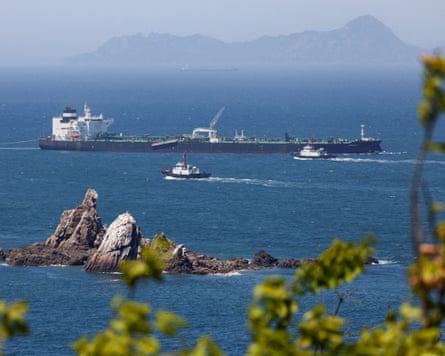 Tugboats guide a tanker carrying UAE crude after passing through the dtrait of Hormuz in May.