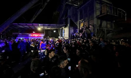 Menschen warten auf Neuigkeiten außerhalb der Zeche.