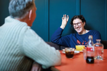 A man and woman facing each other across a restaurant table