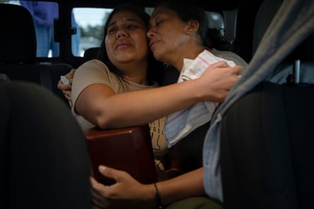 Yaritza García and her daughter, Carmen, hug after receiving the box containing the remains of Alexandra at El Junquito Cemetery on the outskirts of Caracas
