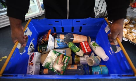 A person holds a basket with food items at Peckham Pantry in London, Britain, 26 April 2023.