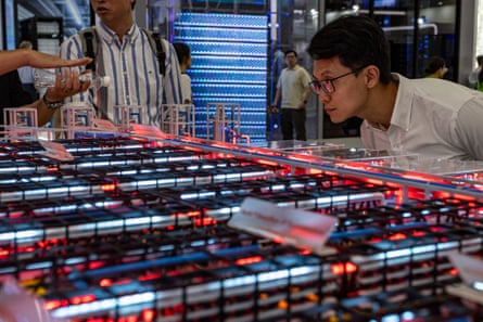 A man leans in to examine the modular grid layout and server configurations of a large datacentre hardware model in Taipei, Taiwan