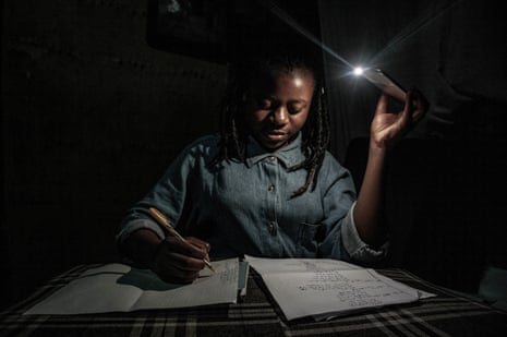 With schools closed during Congo’s period of confinement, 13-year-old Marie studies at home by the light of a mobile phone during one of the regular power cuts in Goma in April.