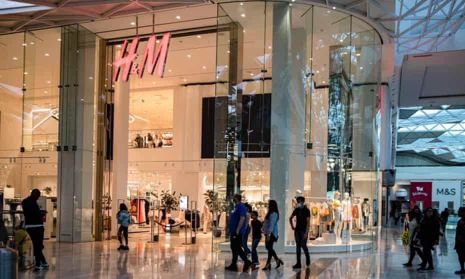 People walking past an H&M shop