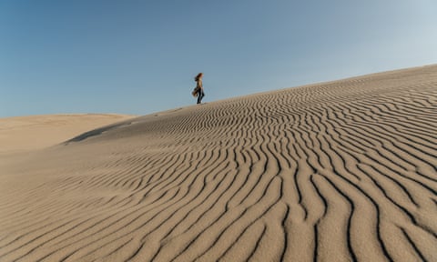 Woman walkng on Råbjerg Mile, the largest migrating sand dune in northern Europe.