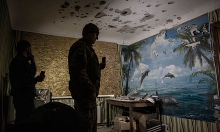 Oleksander Promin, left, and a soldier inspect damage to Yana’s room after it was badly damaged by Russian shelling on Friday.