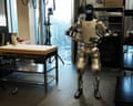 A tall prototype robot stands on two legs in a lab.