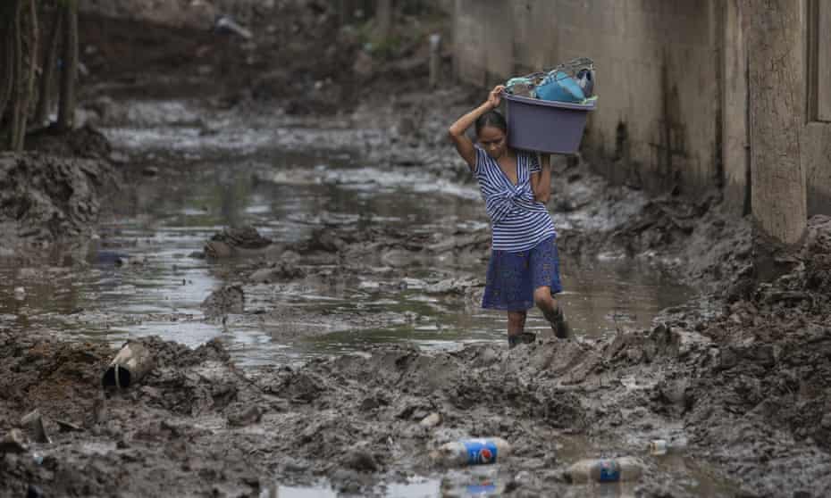 A resident of San Pedro Sula, Honduras, salvages some of her belongings after flooding caused by hurricanes Eta and Iota, January, 2021. 