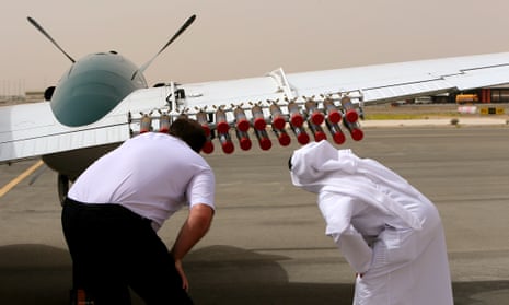 A pilot and a United Arab Emirates official check salt flares on a plane. They will be fired into a cloud to increase condensation and in the hope of triggering rainfall. 