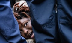 woman's face in distress viewed between legs of police