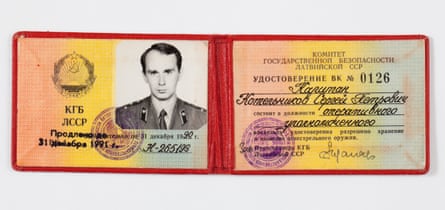 A two part ID card in a wallet with a photo on one side and a certificate on the other, both printed on papaer with a pink yellow and green tint