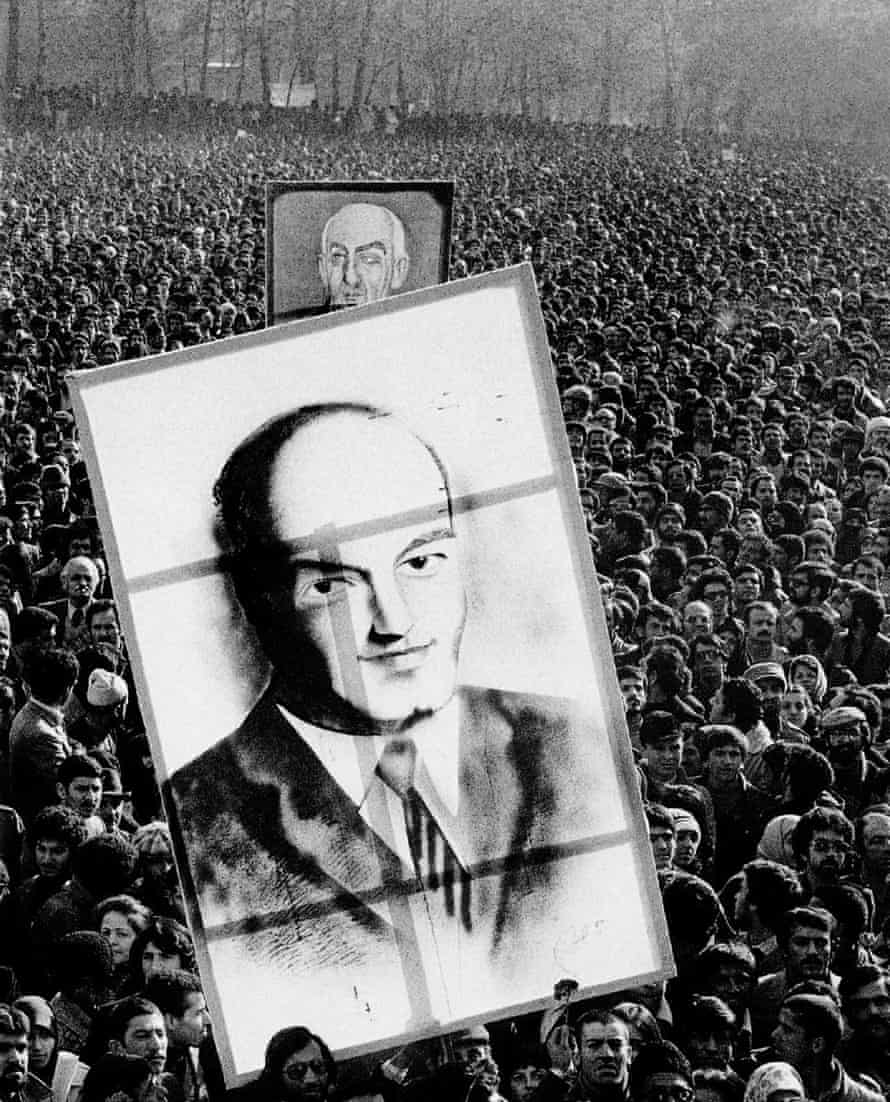 Revolutionaries hold up large pictures of Ali Shariati (front) and Prime Minister Mohammad Mossadegh (back).