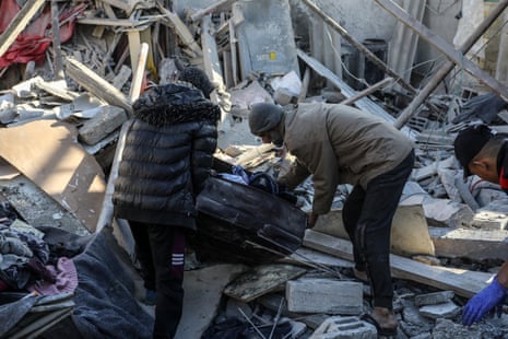 Palestinians inspect and retrieve their belongings from the rubbles of demolished buildings after Israeli attacks on the Zamili family building in Rafah, where 16 people are believed to have been killed.