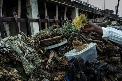 A person reaches for dried herbs on a market stall
