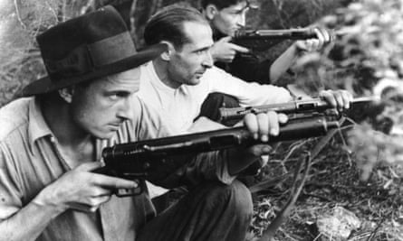 Men in a trench aim rifles.