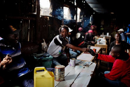 Men drink changaa – home-brewed alcohol – in a bar in Kibera