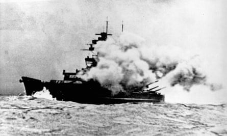 Navire de guerre enveloppé de fumée provenant des tirs des canons principaux 