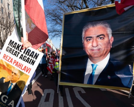 A group of people holding up posters, one of Reza Pahlavi and the other reading ‘make Iran great again’
