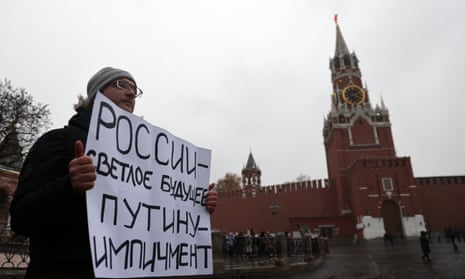 Denis, a protester from Moscow, carries a placard that reads ‘Bright future for Russia, Impeachment for Putin’ during his protest in Red Square in November. He was detained by police.