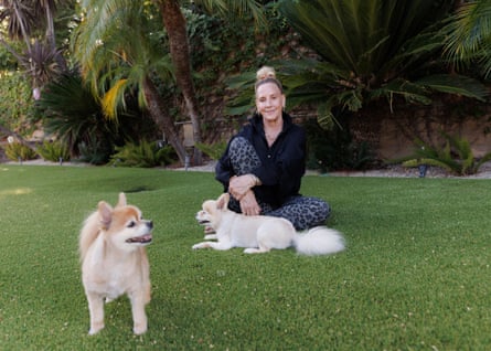 Erin Brockovich sitting on the lawn with two fairly small dogs.