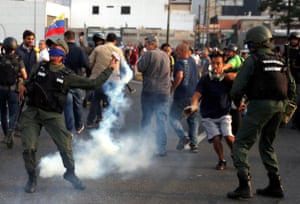 A soldier throws a tear gas canister near the Generalisimo Francisco de Miranda Airbase