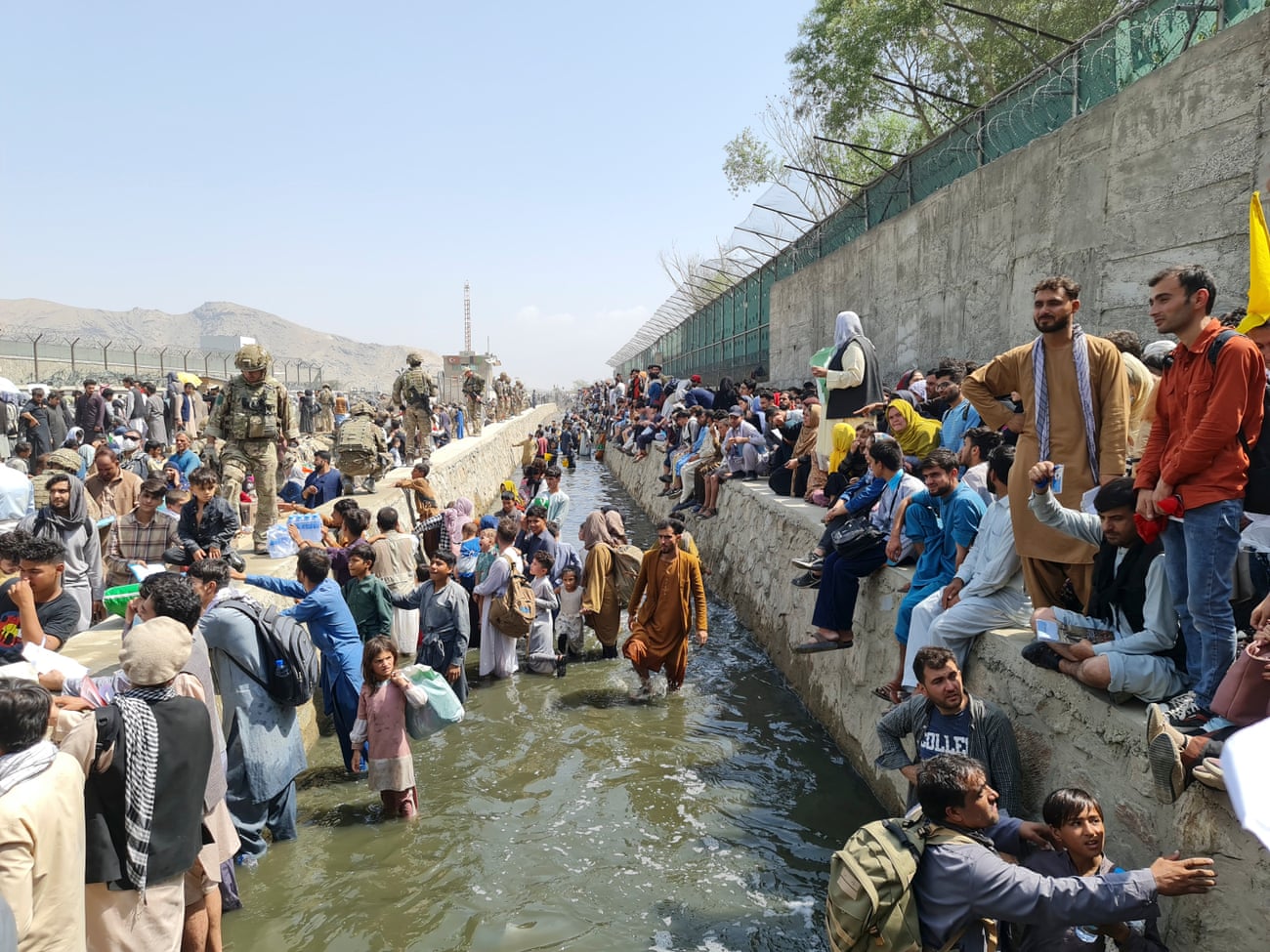 Thousands of Afghan residents trying to evacuate Kabul are stopped by a river of raw effluent