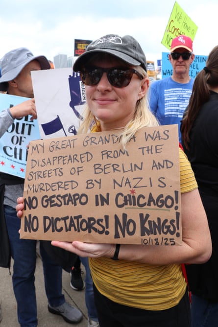 woman smiles outside at protest, holding a sign saying ‘My great grandma was disappeared from the streets of berlin and murdered by nazis. No gestapo in chicago! no dictators! no kings!’