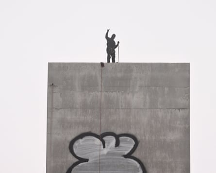 A man gestures from the top of the eastern pylon of the Bolte Bridge in Melbourne.