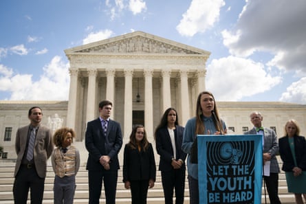 a woman speaks into a microphone at a lectern with a banner that reads ‘let the youth be heard’