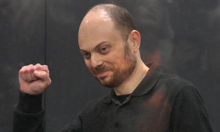 Vladimir Kara-Murza raises his fist in the air.