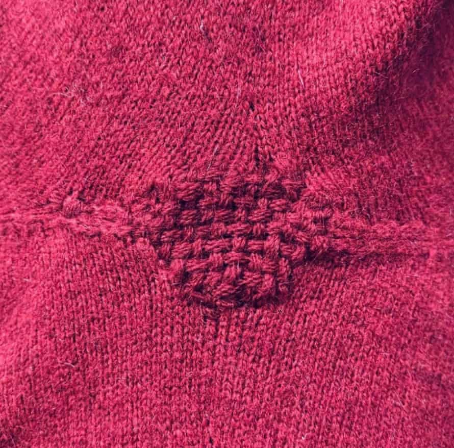 A pink sweater that has been repaired.