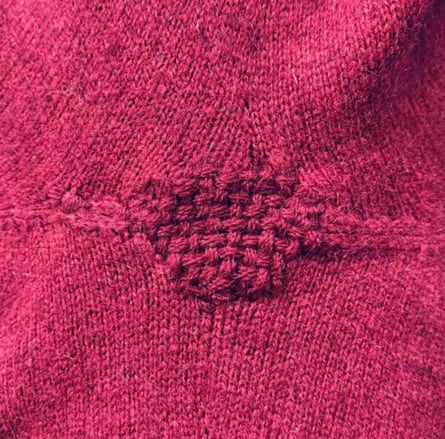 A pink jumper which has been repaired.