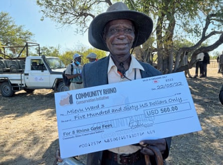 Baba Mvelo, 88, headman of Ward 3, Tsholotsho Community, holds the first cheque for tourist visits to see the reintroduced rhinos in Zimbabwe.