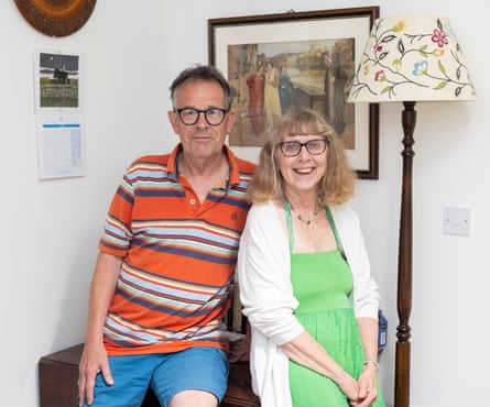 Martin and Pat Prestage smiling in their home next to a lamp