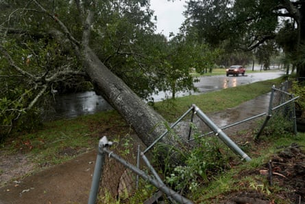 A fallen tree blocks a street as wind and rain from Hurricane Isaias approach the area