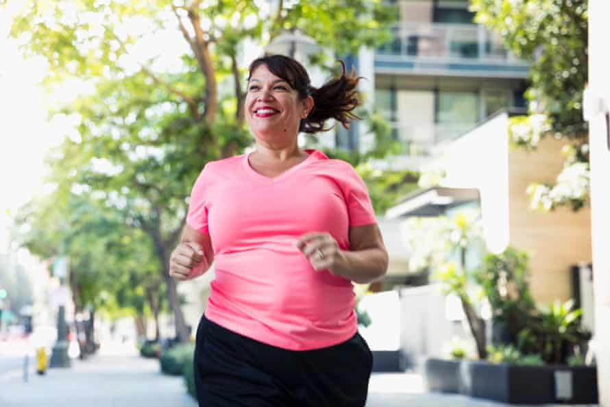 Cheerful woman jogging on footpath in cityUSA, California, Los Angeles