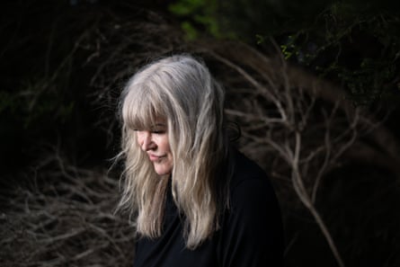 Vera Gazzard leans forward, with wind swept blonde hair, in the evening light in shrubland at Torquay on Victoria’s Surf Coast