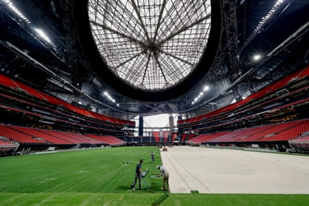 Workers install the playing surface at the Mercedes-Benz Stadium in Atlanta
